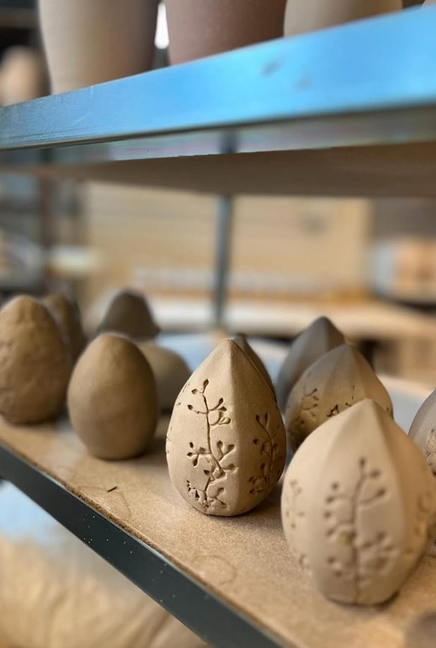 Små ler figur med blomster print klar til at blive brændt.